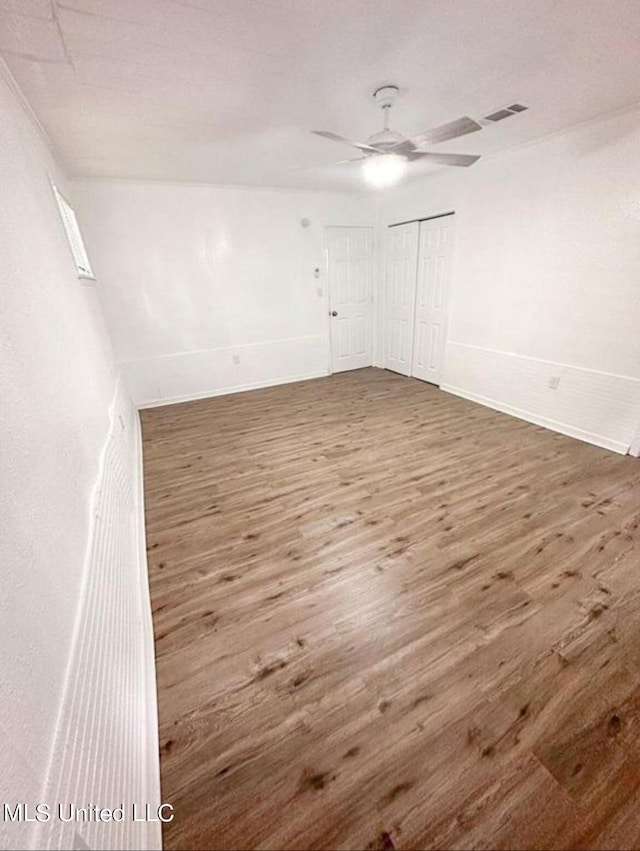 unfurnished room featuring dark wood-type flooring and ceiling fan