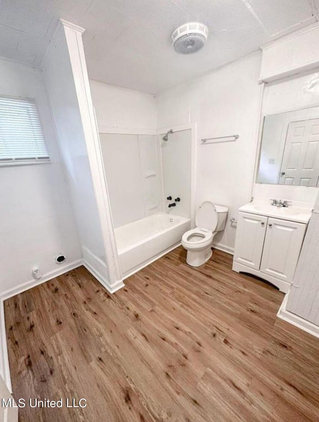 full bathroom with toilet, vanity, wood-type flooring, and washtub / shower combination