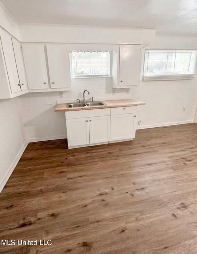 kitchen featuring sink, white cabinetry, and hardwood / wood-style flooring