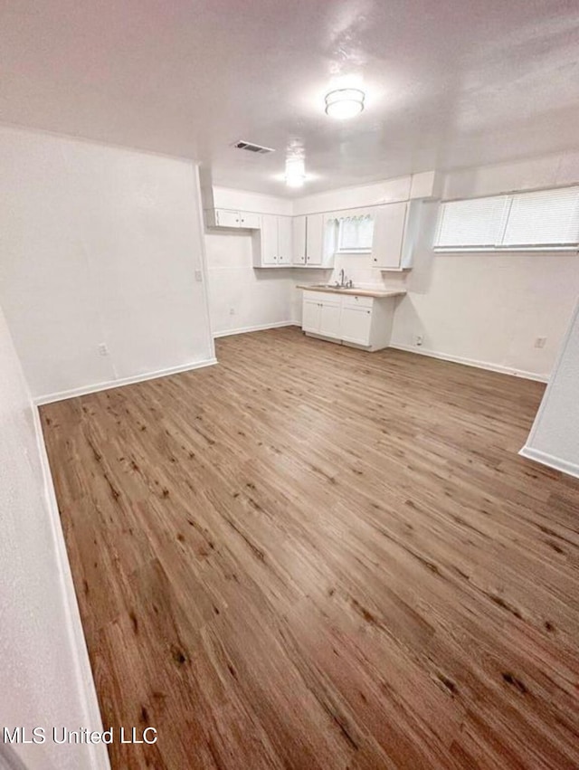 unfurnished living room with wood-type flooring and sink