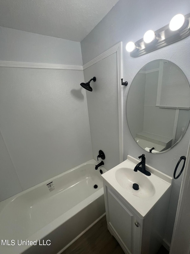 bathroom featuring a bath, hardwood / wood-style flooring, a textured ceiling, and vanity