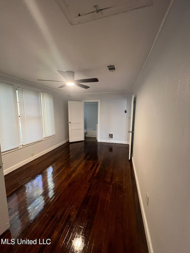 empty room featuring dark wood-type flooring and ceiling fan