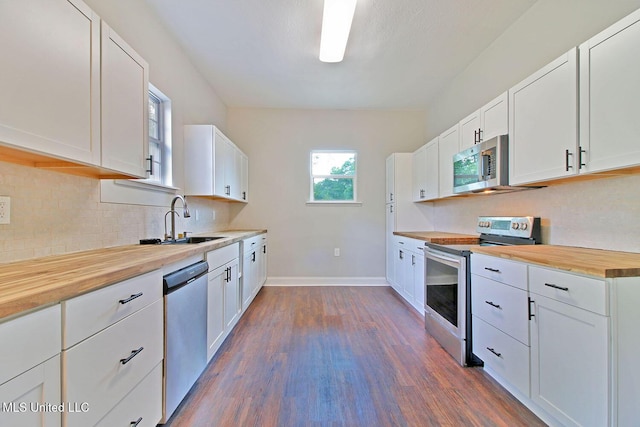 305 First Ave, New Augusta, MS 39462 - kitchen featuring appliances with stainless steel finishes, wood counters, a sink, dark wood-type flooring, and baseboards