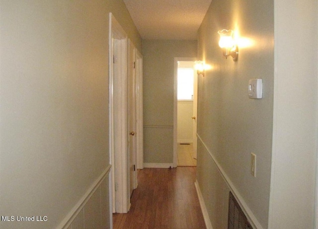 hall featuring wood finished floors and baseboards