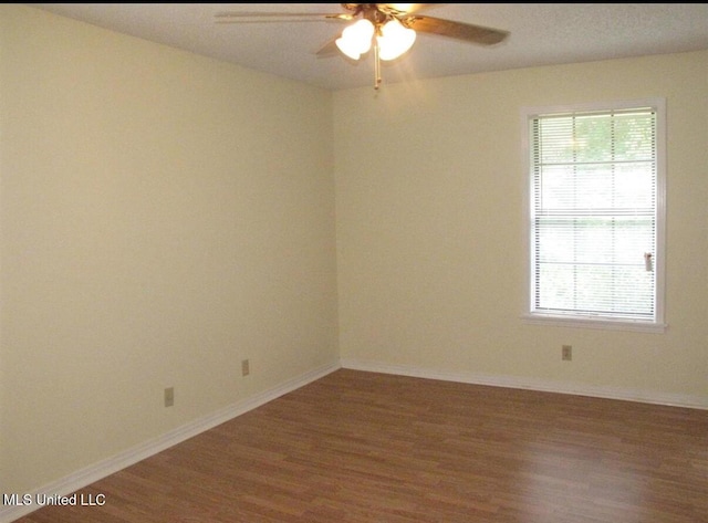 unfurnished room with wood finished floors, a ceiling fan, and plenty of natural light