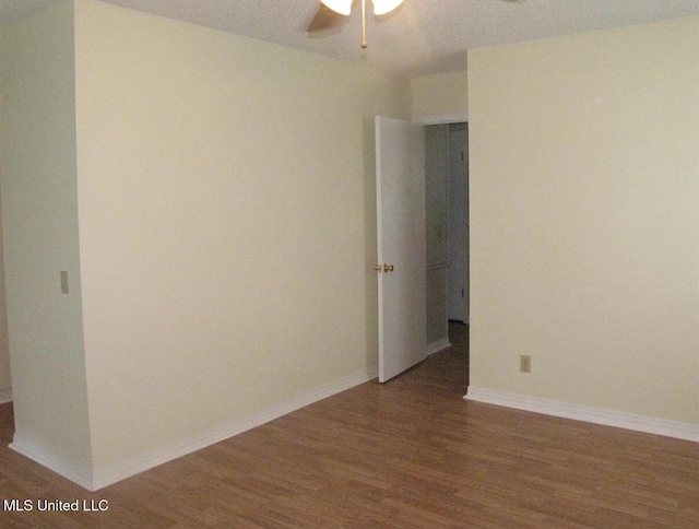 spare room featuring wood finished floors, ceiling fan, and baseboards