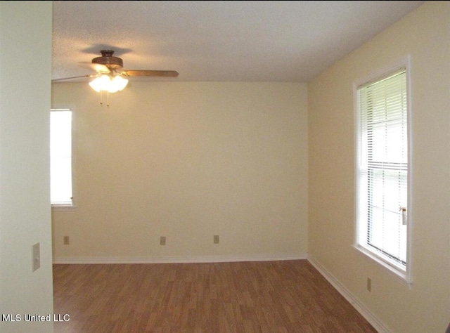 spare room featuring ceiling fan, wood finished floors, and baseboards