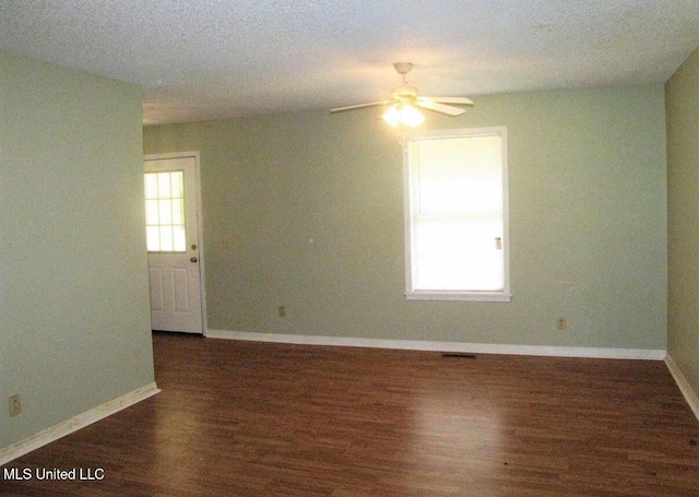 empty room featuring wood finished floors, a ceiling fan, and baseboards