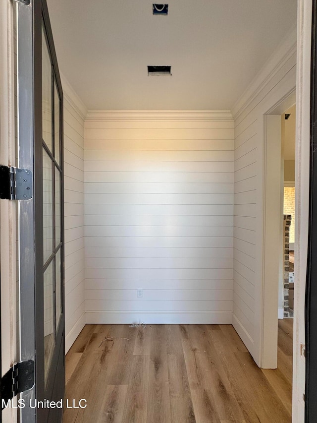 spare room with crown molding and light hardwood / wood-style floors