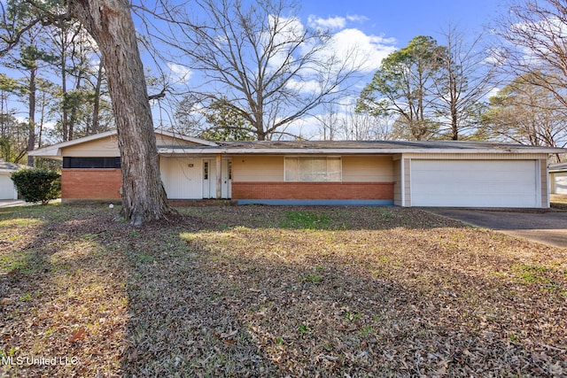 view of front of property featuring concrete driveway, a garage, and brick siding