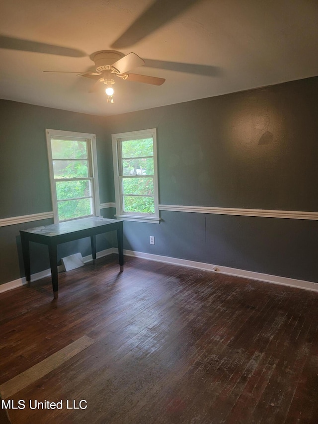 unfurnished office featuring dark wood-type flooring and ceiling fan