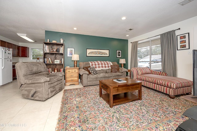 tiled living room featuring a wealth of natural light and a textured ceiling