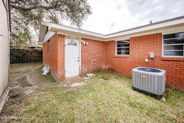 exterior space featuring central AC unit and a lawn