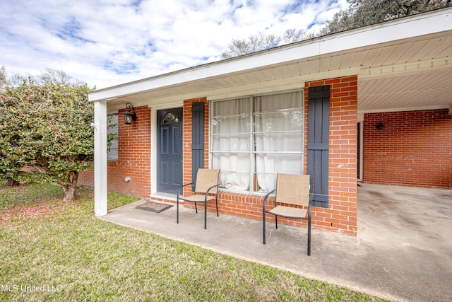 doorway to property with a porch and a lawn