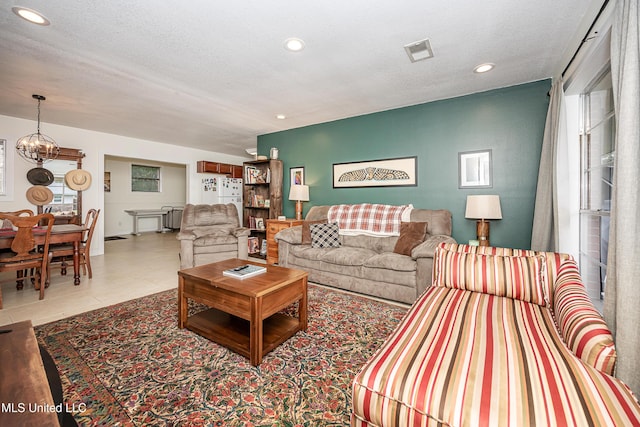 living room featuring a chandelier, a textured ceiling, and light tile patterned floors