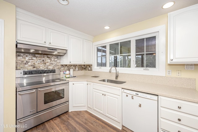 kitchen with white cabinets, white dishwasher, range with two ovens, and a sink