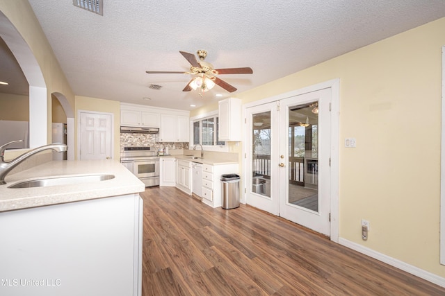 kitchen featuring white cabinets, range with two ovens, a sink, and light countertops