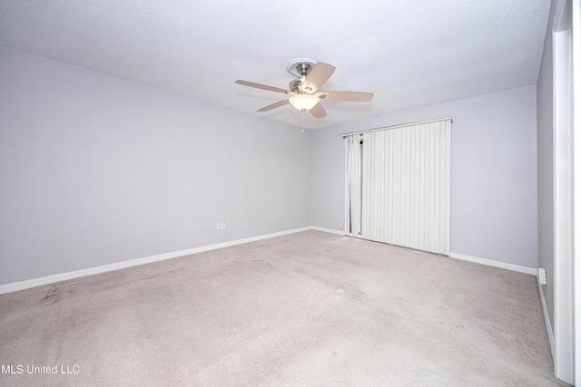 unfurnished bedroom featuring baseboards, a textured ceiling, a ceiling fan, and light colored carpet