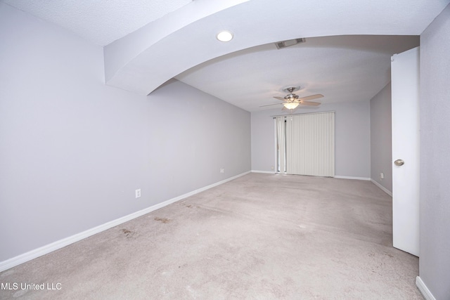 interior space with arched walkways, visible vents, light carpet, ceiling fan, and baseboards