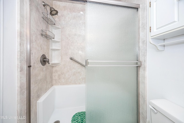 bathroom with a shower stall and toilet