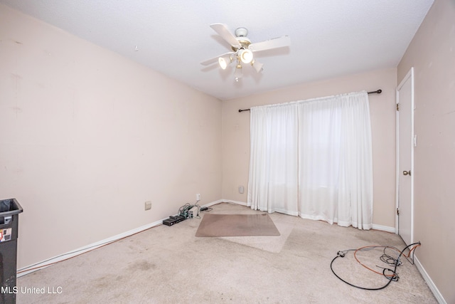 empty room featuring light carpet, ceiling fan, and baseboards