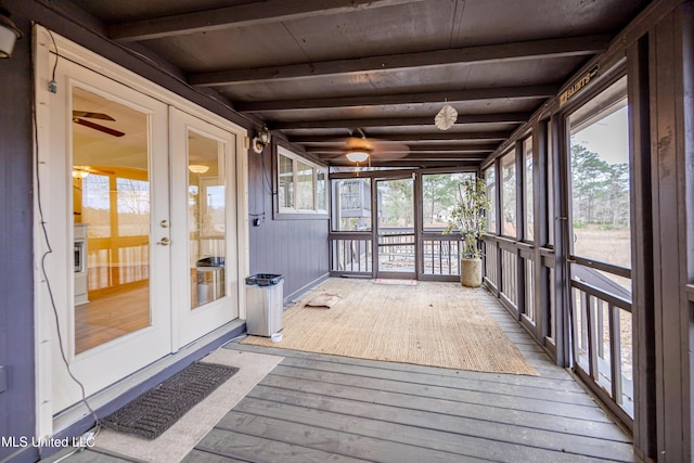 unfurnished sunroom with beam ceiling and french doors