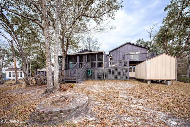 back of house featuring a sunroom, a deck, and stairs