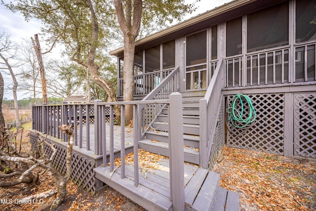 wooden deck with a sunroom and stairs