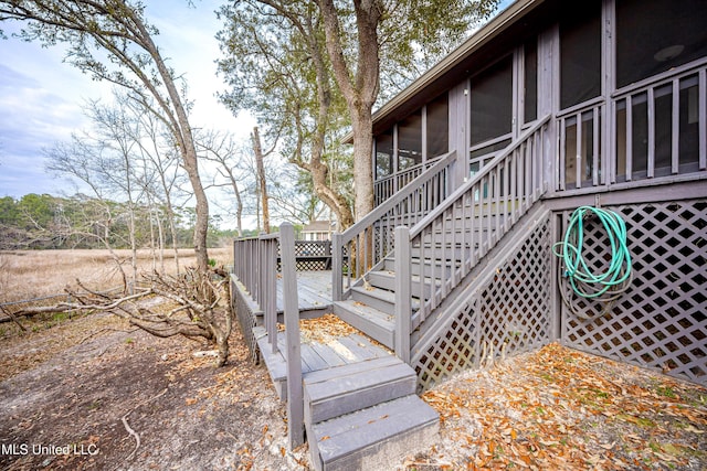 exterior space with a deck, a sunroom, and stairway