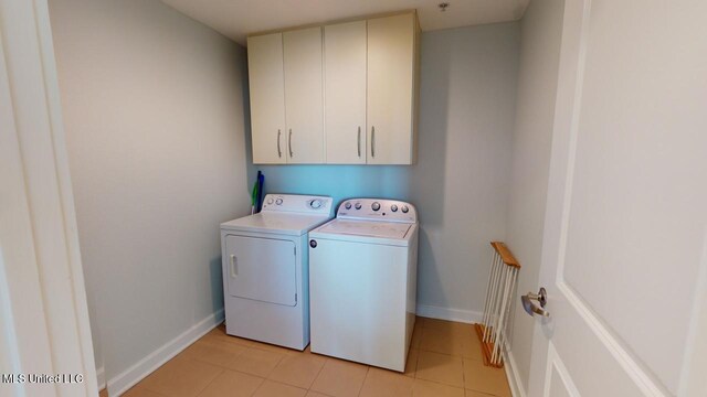 2060 Beach Blvd Unit 701, Biloxi, MS 39531 - laundry area with cabinet space, washer and dryer, baseboards, and light tile patterned floors