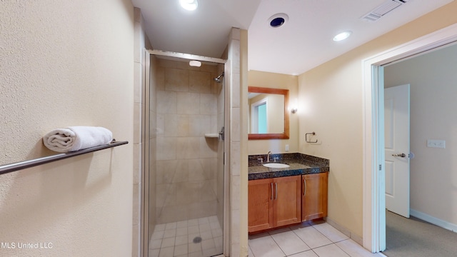 bathroom featuring a shower with door, vanity, and tile patterned flooring