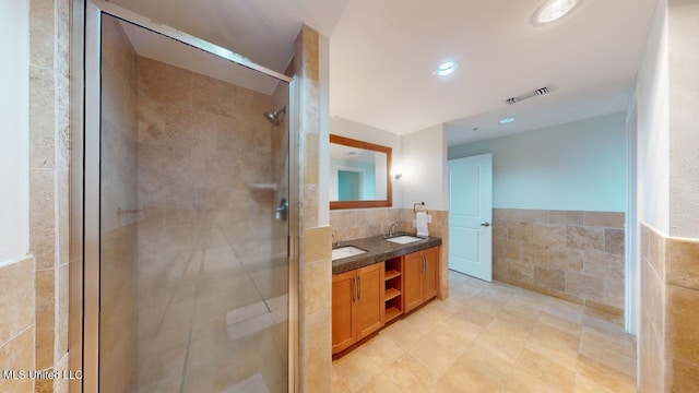 2060 Beach Blvd Unit 701, Biloxi, MS 39531 - bathroom with tile walls, a stall shower, double vanity, a wainscoted wall, and recessed lighting