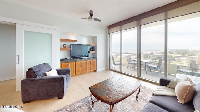 2060 Beach Blvd Unit 701, Biloxi, MS 39531 - living room featuring plenty of natural light, light tile patterned floors, a ceiling fan, baseboards, and a textured ceiling