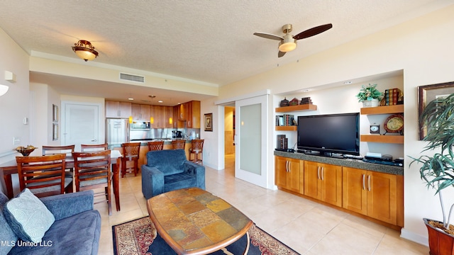 living room with a textured ceiling, light tile patterned floors, and ceiling fan