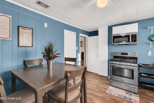 1264 28th St, Gulfport, MS 39501 - dining room with wood finished floors, a ceiling fan, and crown molding