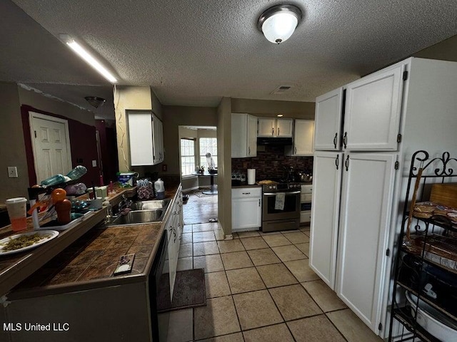 53 Flagstaff St, Lumberton, MS 39455 - kitchen featuring stainless steel range with electric stovetop, a textured ceiling, white cabinetry, light tile patterned floors, and range hood