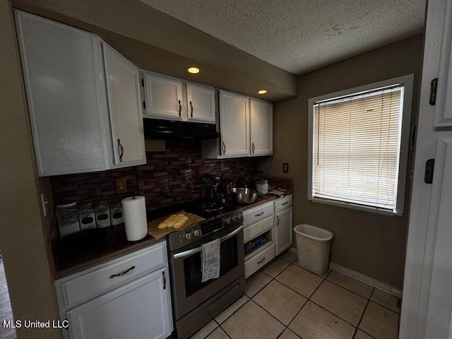 53 Flagstaff St, Lumberton, MS 39455 - kitchen featuring stainless steel stove, ventilation hood, tasteful backsplash, dark countertops, and white cabinetry