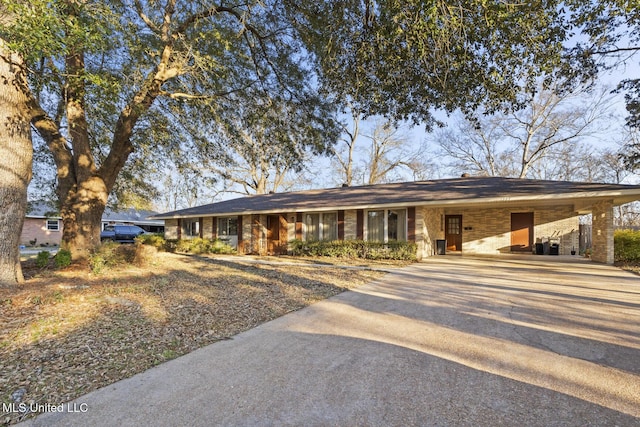 ranch-style home featuring concrete driveway and brick siding