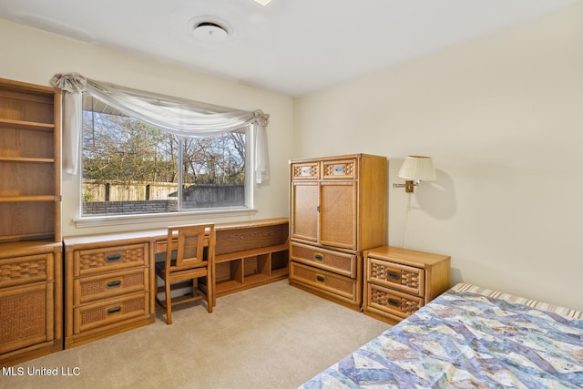 bedroom featuring light carpet and built in study area