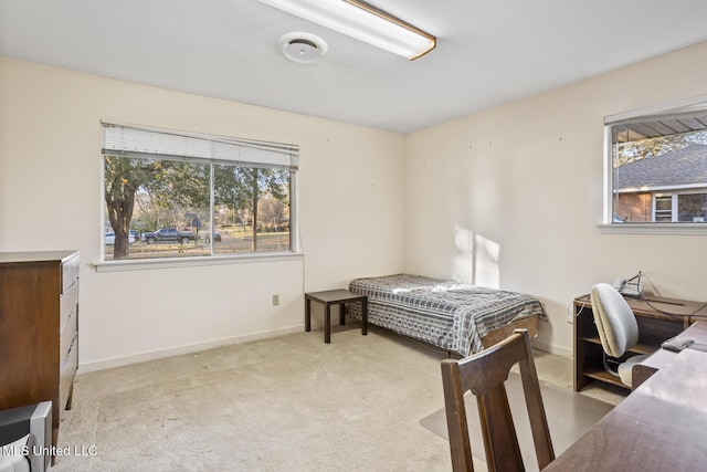 bedroom with light carpet, baseboards, and multiple windows