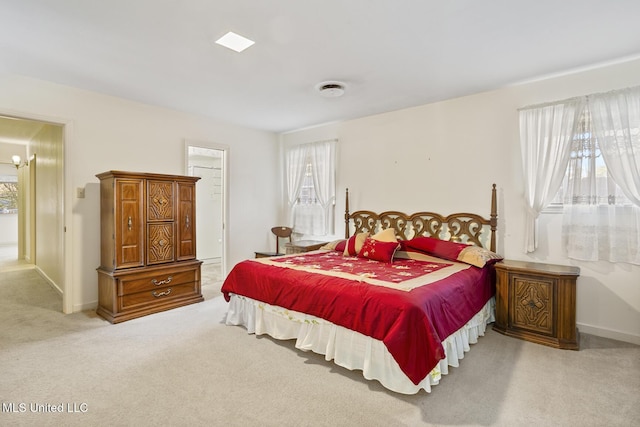 bedroom with light carpet and baseboards