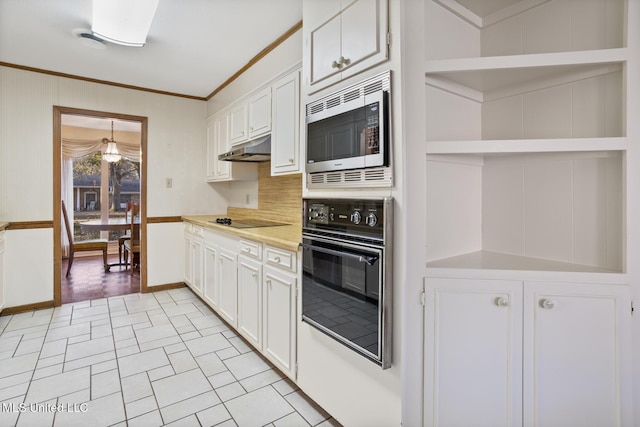 kitchen featuring ornamental molding, under cabinet range hood, light countertops, black appliances, and white cabinetry