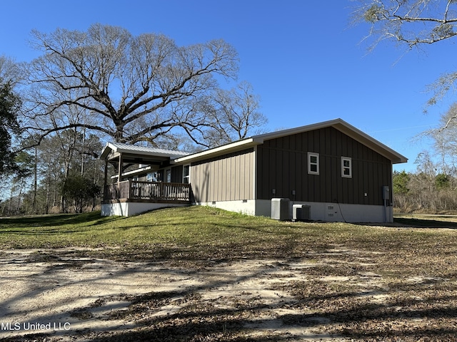 view of home's exterior featuring crawl space, board and batten siding, central AC unit, and a lawn