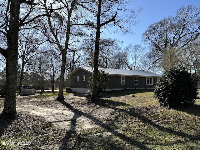 view of front of property with dirt driveway and metal roof