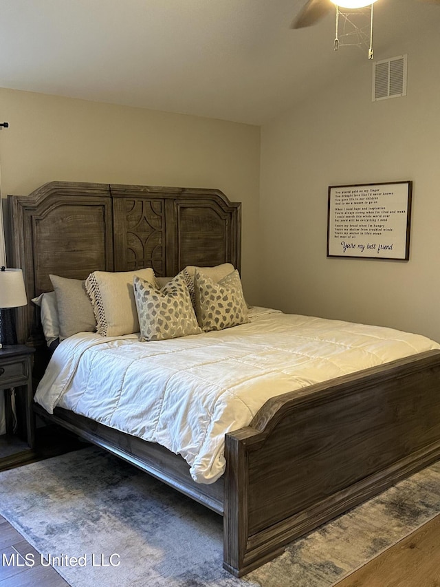 bedroom with a ceiling fan, visible vents, and wood finished floors