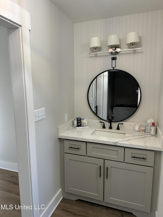 bathroom featuring baseboards, wood finished floors, and vanity