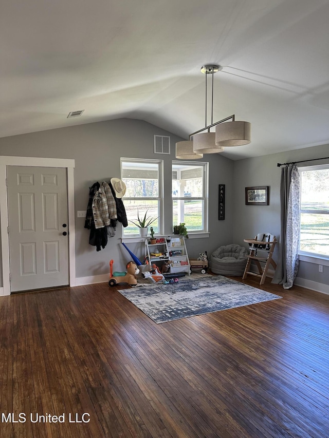 unfurnished living room with lofted ceiling, visible vents, baseboards, and hardwood / wood-style flooring