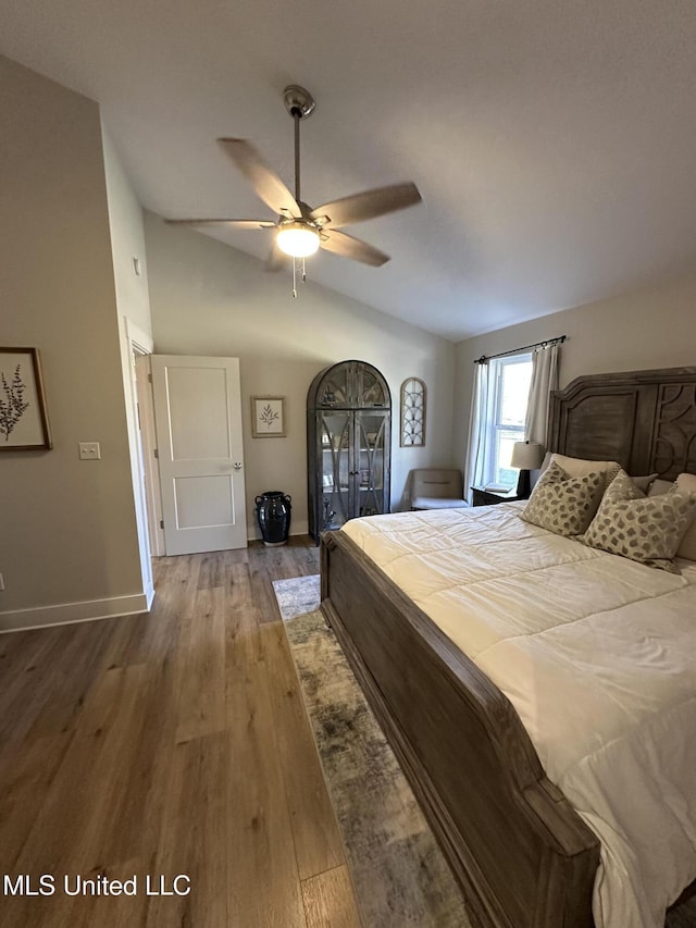 bedroom with lofted ceiling, wood finished floors, a ceiling fan, and baseboards