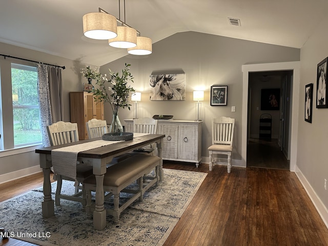 dining room with lofted ceiling, visible vents, baseboards, and wood finished floors