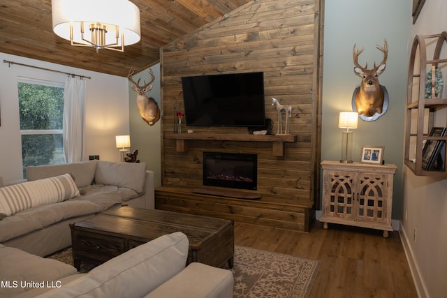 living area with baseboards, wood ceiling, wood finished floors, vaulted ceiling, and a fireplace